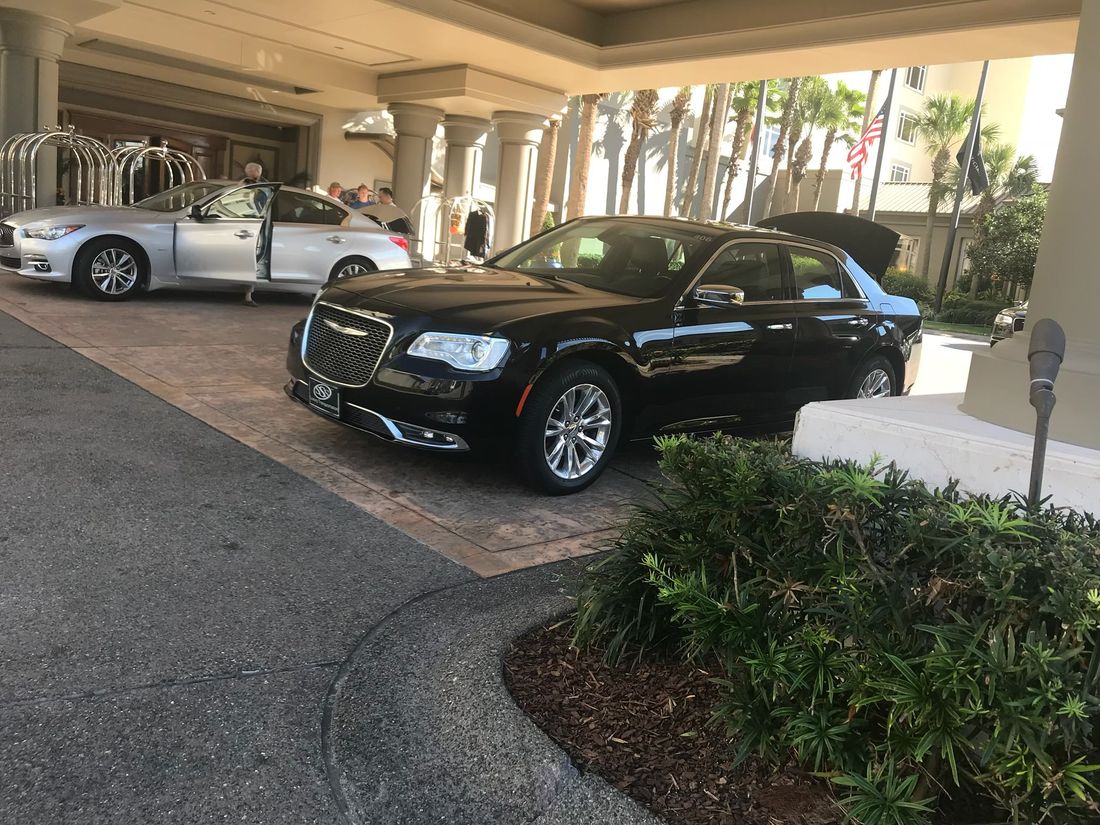 Executive black sedan at a hotel entrance